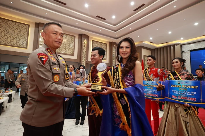 Kapolda Jatim Irjen Drs. Imam Sugianto memberikan piala kepada Aliyah Afifah Salim, juara 1 Duta Lalu Lintas perempuan dari polres Gresik.(dok. Polda Jatim)