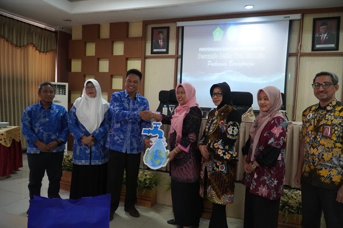 Direktur Administrasi dan Keuangan Perumda Delta Tirta Laily Agustin, berjabat tangan bersama pengunjung Puskesmas Barengkrajan, Krian.