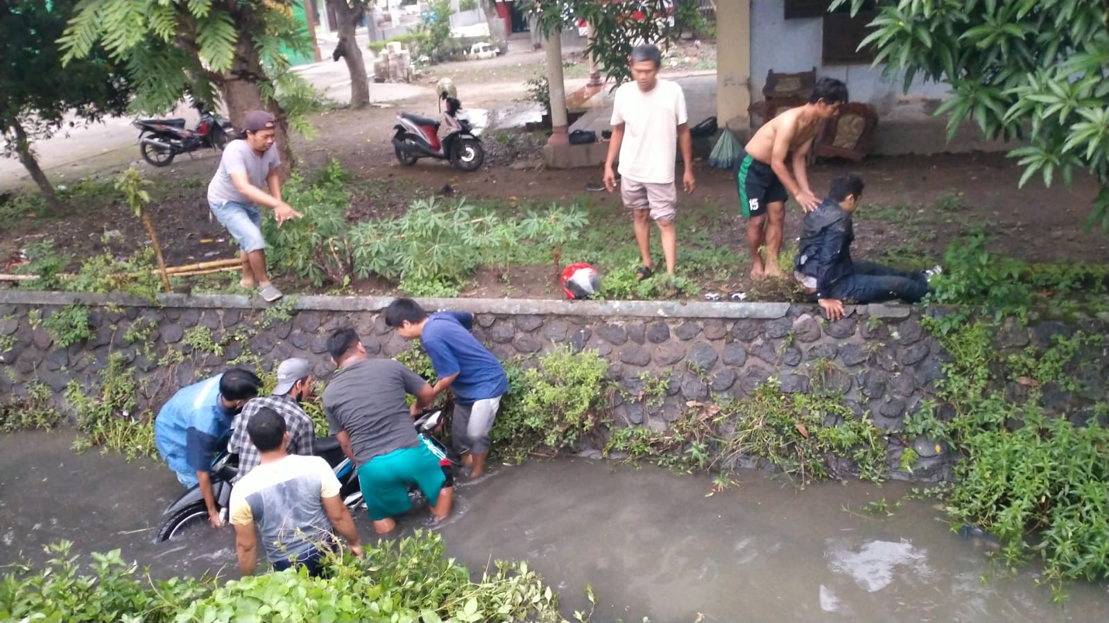 Pengendara motor di Mojokerto masuk sungai usai diseruduk mobil box.(blok-a.com/Syahrul)