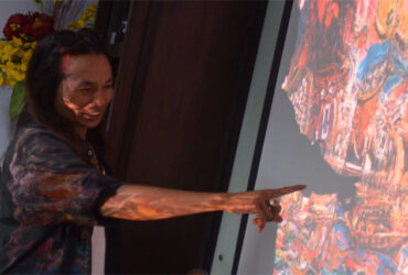 Jansen Jasien dan lukisannya. (dok. Suarasurabaya)