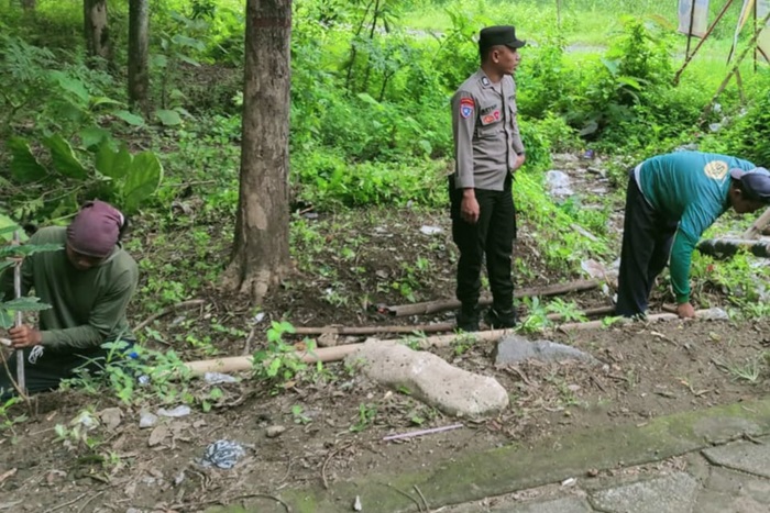 Anggota Polsek Karanganyar bersih-bersih saluran air di Dusun Payak, Kecamatan Karanganyar, Kabupaten Ngawi.