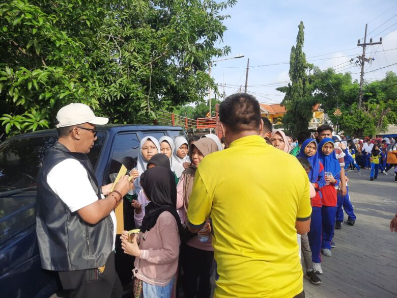 Teks Foto : Kadis Parporaekraf Gresik turun tangan membagikan kupon hadiah Jalan Sehat (blok-a.com/ivan)