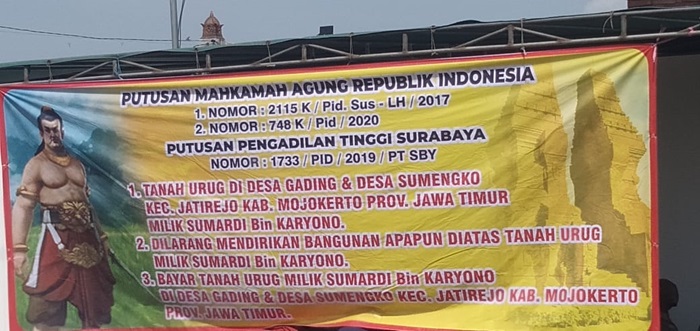 Banner bertuliskan putusan Mahkamah Agung RI dan Putusan Pengadilan Tinggi Surabaya.(Blok-a.com/Syahrul)
