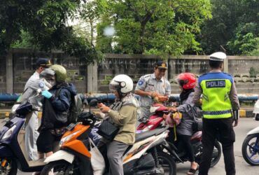 Anggota Satlantas Polres Gresik kampanye keselamatan berkendara dengan bagikan coklat ke pengguna jalan.(blok-a.com/ivan)