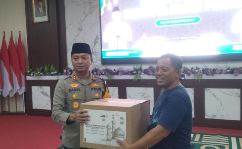 Kapolres Mojokerto Kota AKBP Daniel S. Marunduri, S.I.K., M.H., memberikan simbolis bingkisan lebaran kepada ketua PWI Mojokerto, Sholahudin. (Blok-a.com/Syahrul)