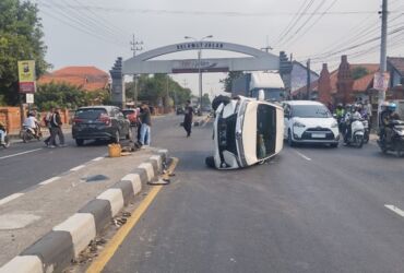 Kondisi mobil Toyota Avanza yang terguling setelah menabrak median jalan di depan Polsek Sooko.(Blok-a.com/Syahrul Wijaya)