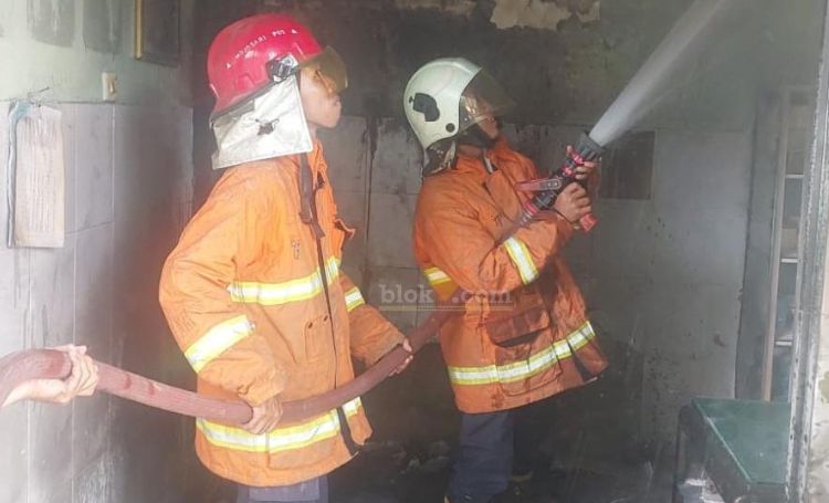 Petugas kebakaran sedang melakukan pembasahan di ruang imunisasi Puskesmas Kutorejo.(Blok-a.com/Syahrul Wijaya)