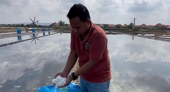Salah satu petani garam saat memperlihatkan hasil panennya (blok-a.com)
