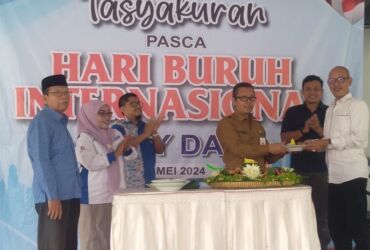 Potong tumpeng oleh Plt Disnakertrans dalam acara tasyakuran pasca Hari Buruh Internasional di kantor Disnakertrans.(blok-a.com/Syahrul Wijaya)