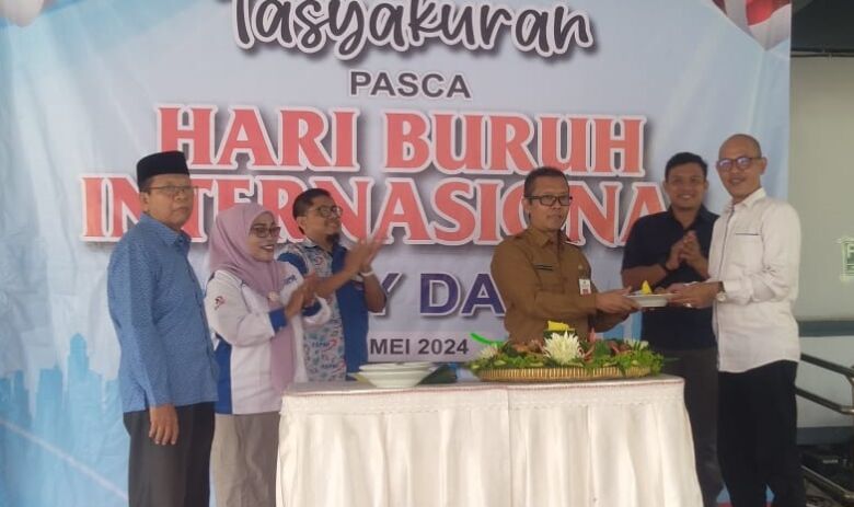 Potong tumpeng oleh Plt Disnakertrans dalam acara tasyakuran pasca Hari Buruh Internasional di kantor Disnakertrans.(blok-a.com/Syahrul Wijaya)