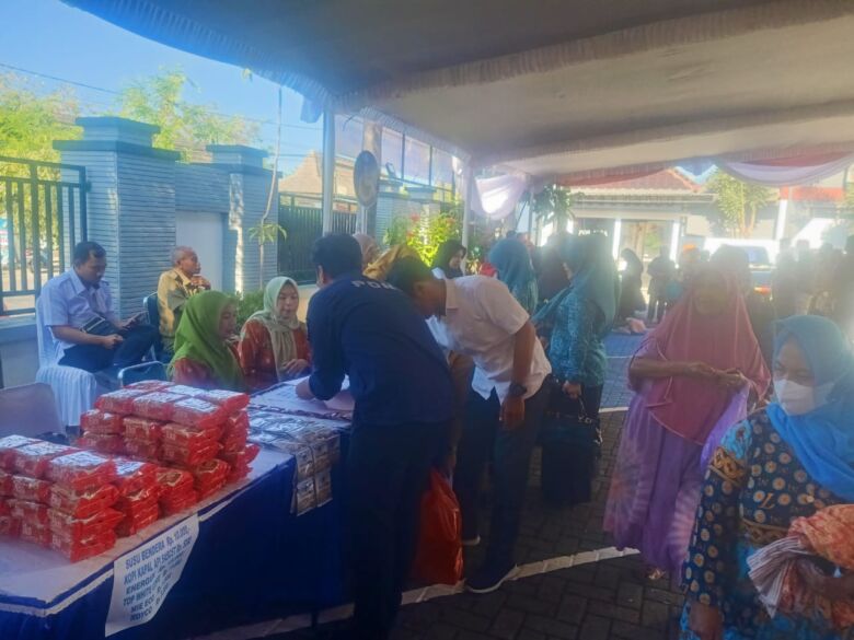 Puluhan warga mengantre untuk membeli bapok murah di halaman kantor Kejari Magetan.