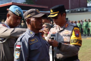Kapolres Mojokerto Kota menyematkan pita kepada anggota linmas.(dokumen Polres Mojokerto kota)