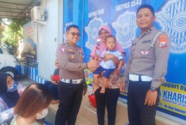 Kanit Regident Ipda Azmi dan Kanit Turjawali Ipda Anjas saat memberikan bunga ke salah satu masyarakat