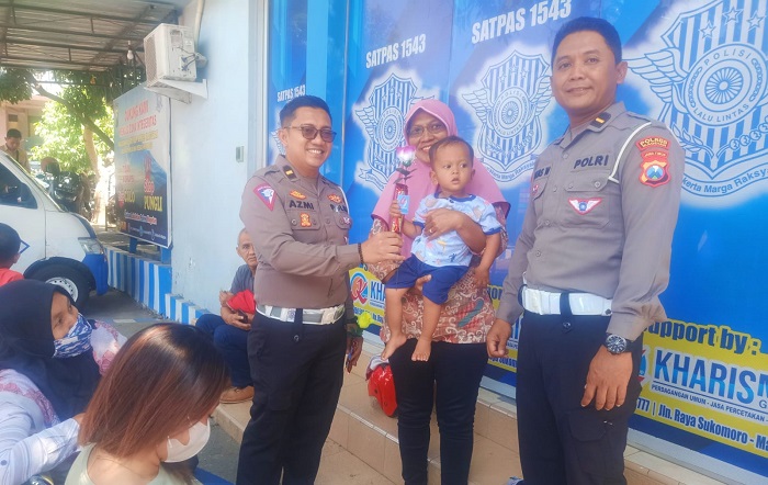 Kanit Regident Ipda Azmi dan Kanit Turjawali Ipda Anjas saat memberikan bunga ke salah satu masyarakat