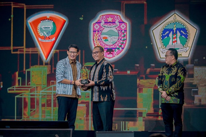 Menparekraf Sandiaga Uno menyerahkan penghargaan Apresiasi Daerah Peduli Inovasi Ekonomi Kreatif dan Pariwisata dari Kompas TV kepada Sekda Kabupaten Gresik Achmad Washil.