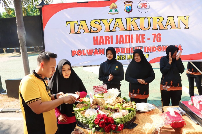 Wakapolres Magetan Kompol Ari Taufan didampingi Pj Ketua Bhayangkari Magetan Ny Dellen Arie Taufan memberi potongan tumpeng kepada Polwan tertua dan termuda.