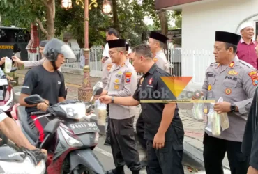 Teks: Kapolres Mojokerto AKBP Andi Yudha Pranata (tengah: memakai baju dinas dan berpeci) saat membagikan takjil kepada para pengguna jalan di depan rumah dinas di jalan Pahlawan Kota Mojokerto.(blue k-a.com/Syahrul Wijaya)