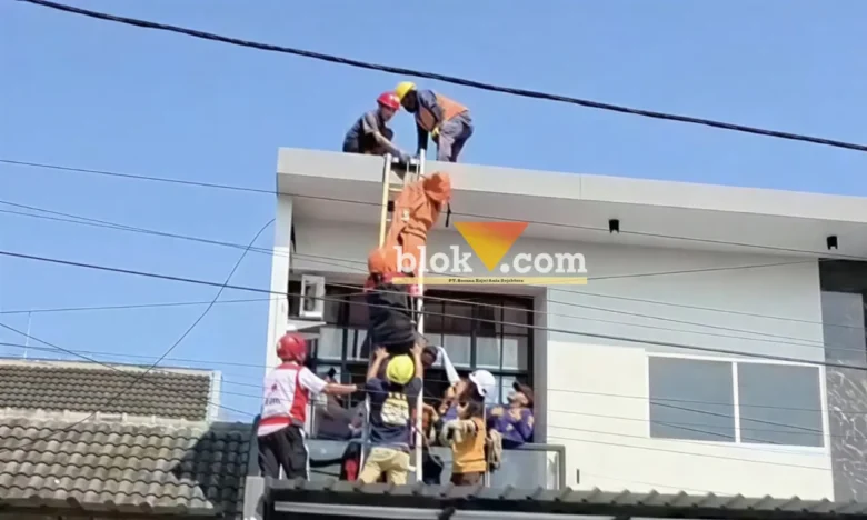 Proses evakuasi korban tersengat listrik di atas atap rumah tingkat.(blok-a.com/Syahrul Wijaya)